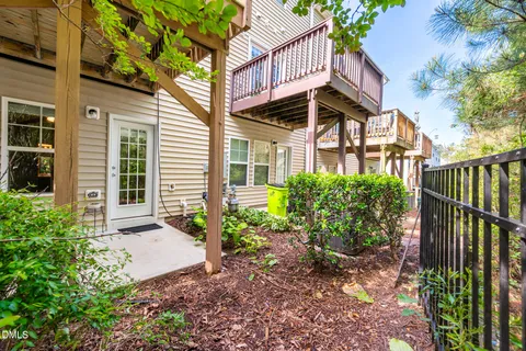 a view of a brick house with plants and a flower garden