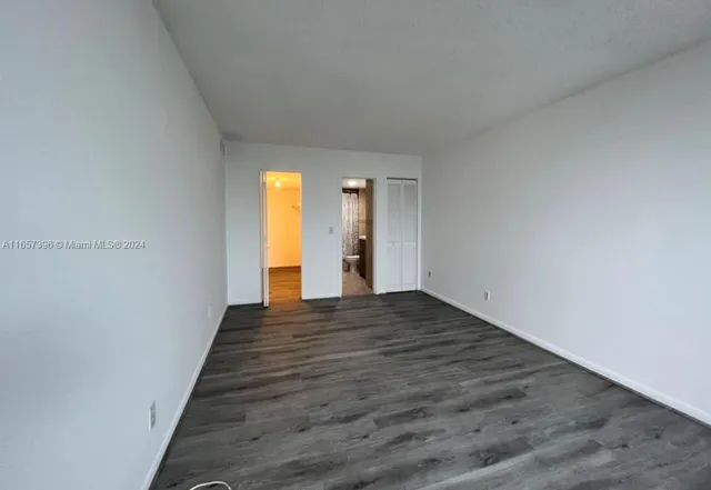 a view of a hallway with wooden floor and closet