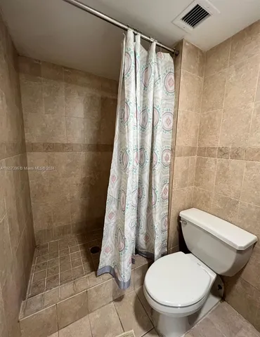 a white toilet sitting next to a shower curtain