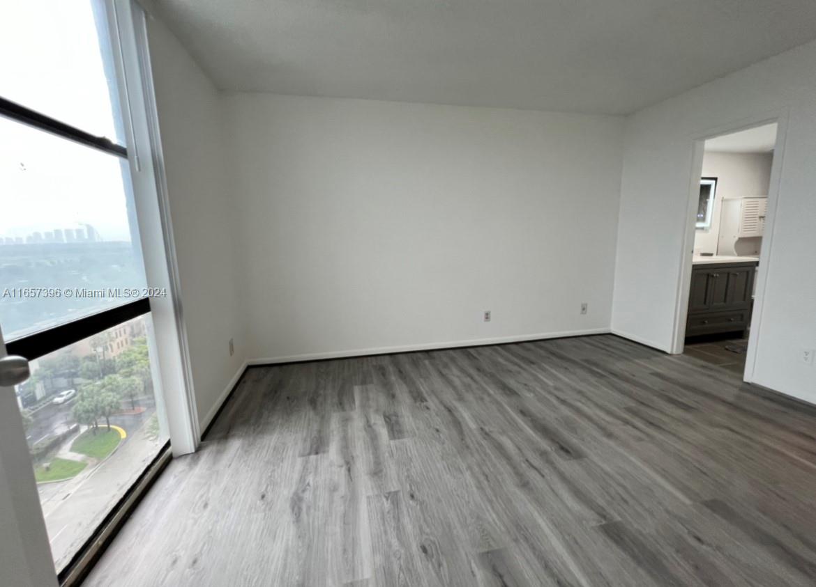 13499 Biscayne Boulevard, Unit 1205 North Miami, FL 33181 - Photo 22 of 32 an empty room with wooden floor and windows