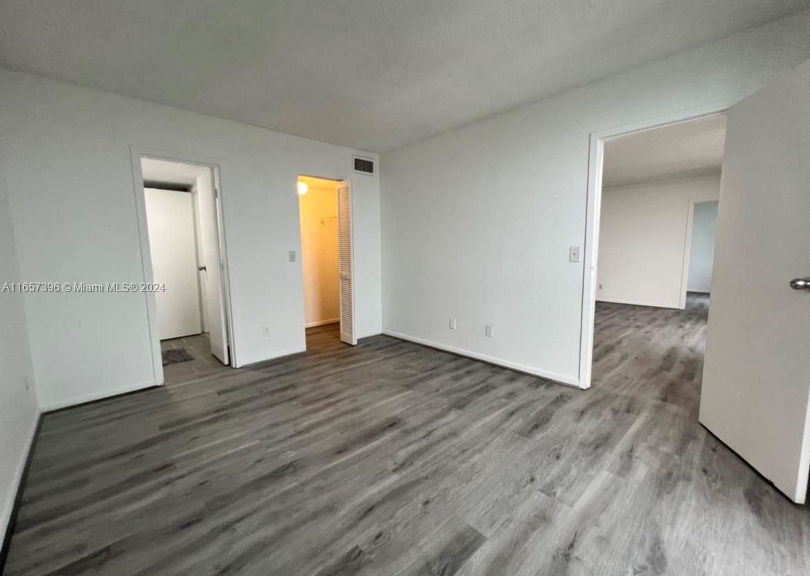 13499 Biscayne Boulevard, Unit 1205 North Miami, FL 33181 - Photo 24 of 32 an empty room with wooden floor and closet