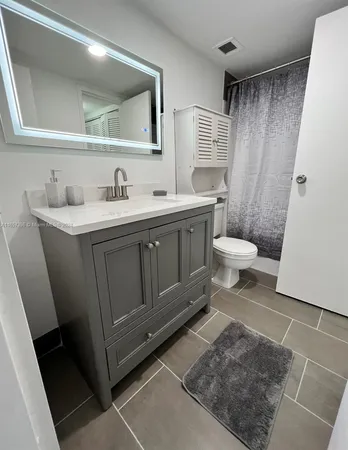 a bathroom with a sink a toilet and a mirror