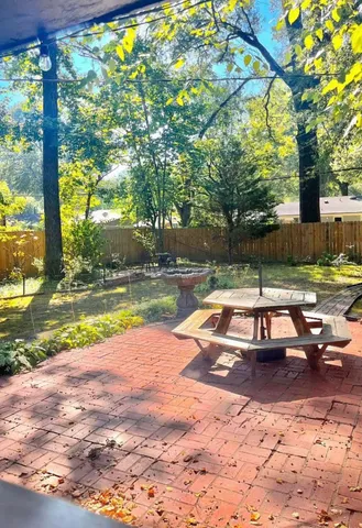 a view of swimming pool with lawn chairs and large trees