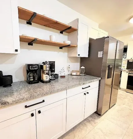 a kitchen with stainless steel appliances granite countertop a sink cabinets and wooden floor