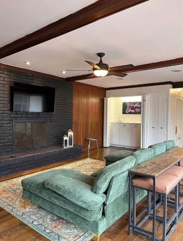 a living room with a bed and a flat screen tv
