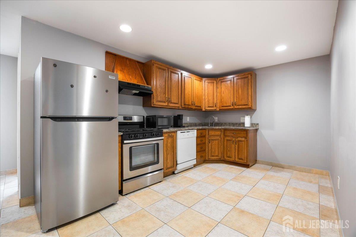 281 Prospect Avenue Old Bridge, NJ 08879 - Photo 11 of 29 a kitchen with stainless steel appliances granite countertop a refrigerator a sink dishwasher a stove with wooden cabinets and a refrigerator