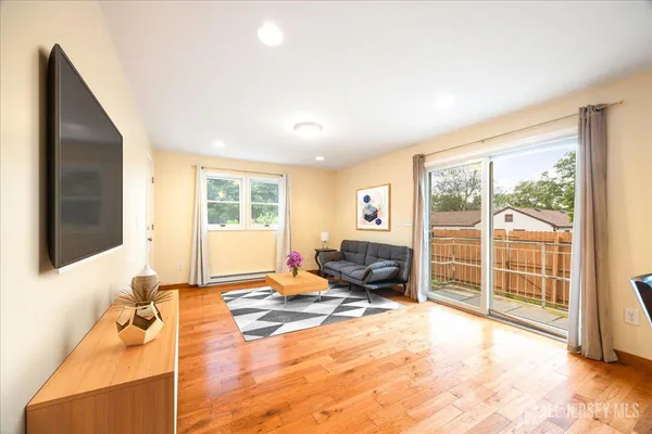 a spacious bedroom with a large bed and a flat tv screen next to a window