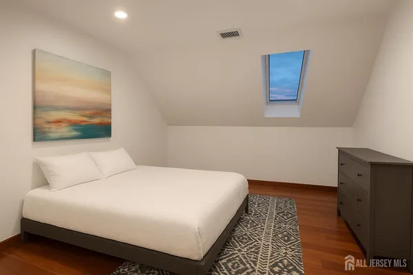 a bedroom with a bed and a painting on the wall