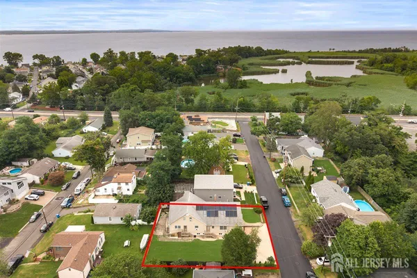 an aerial view of a city with lots of residential buildings and mountain view in back
