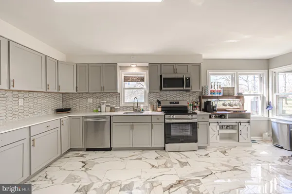 a kitchen with white cabinets a sink and appliances