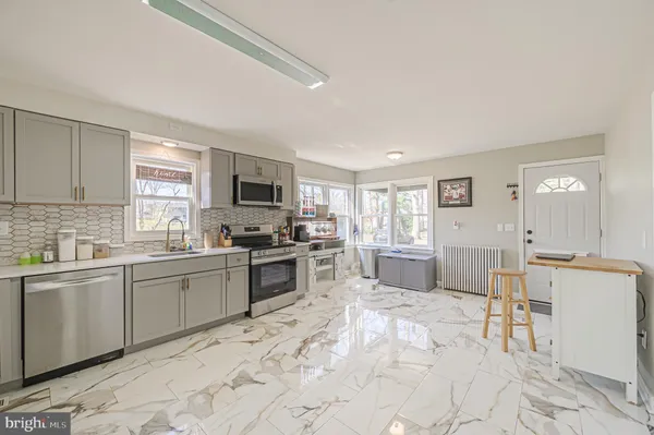 a kitchen with stainless steel appliances kitchen island granite countertop a stove top oven a sink a dining table and chairs