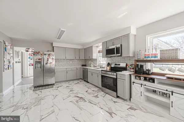 a kitchen with stainless steel appliances granite countertop a stove a sink dishwasher a refrigerator and a microwave
