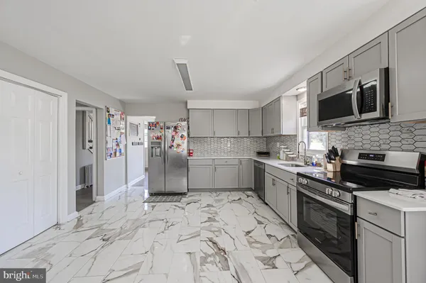 a kitchen with stainless steel appliances granite countertop a refrigerator and a stove top oven