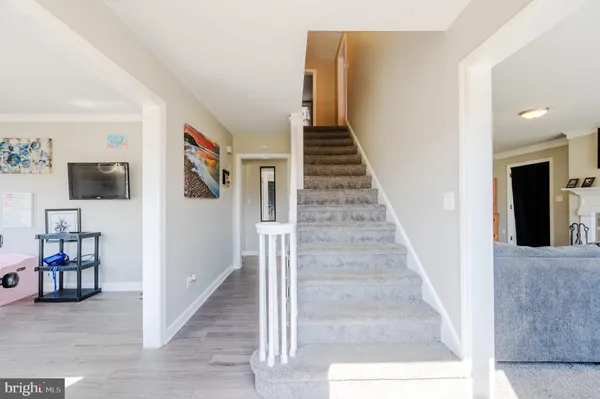 a view of a livingroom with wooden floor and stairs