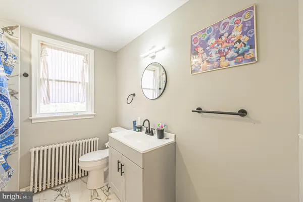 a bathroom with a sink toilet and a window