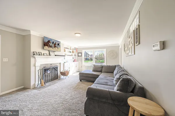a living room with furniture a fireplace and a large window