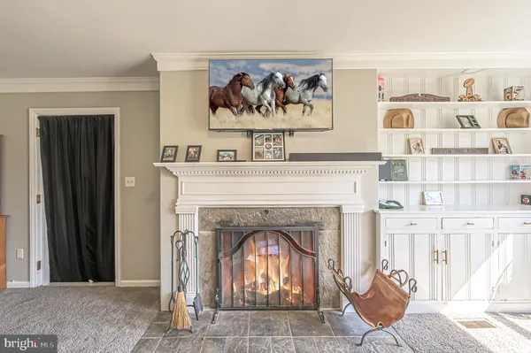 a living room with a fireplace and a painting on the wall