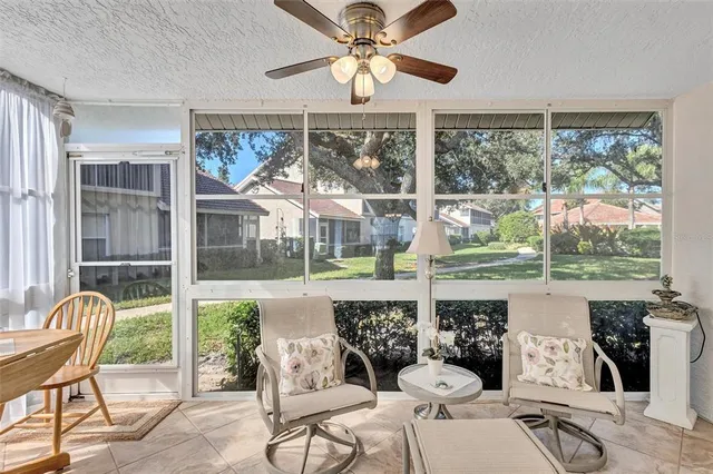 a living room with patio furniture and a floor to ceiling window