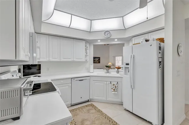 a kitchen with cabinets a sink and white appliances