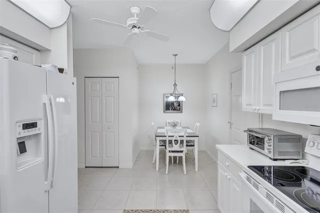 a kitchen with stainless steel appliances a table chairs and a refrigerator