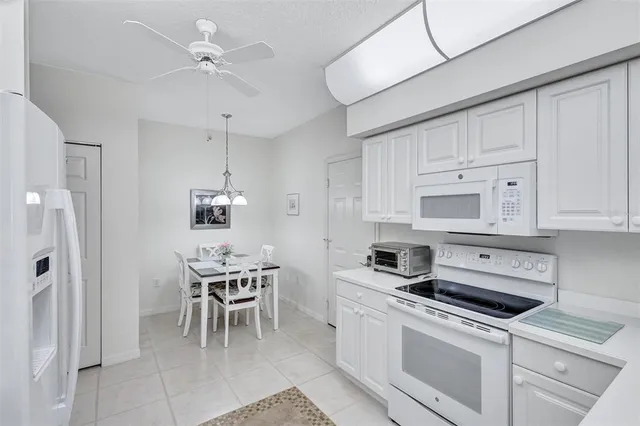 a kitchen with a white cabinets and chairs
