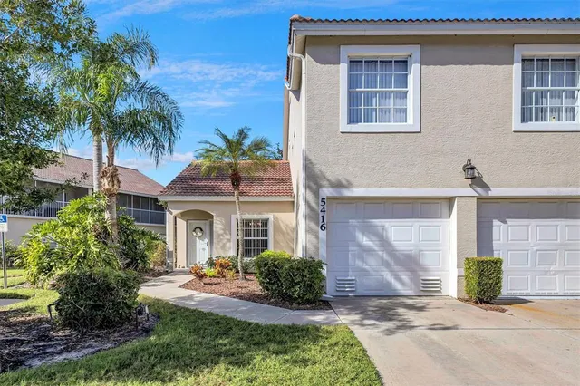a front view of a house with yard and tress