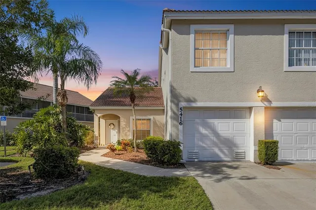a front view of a house with a yard and potted plants
