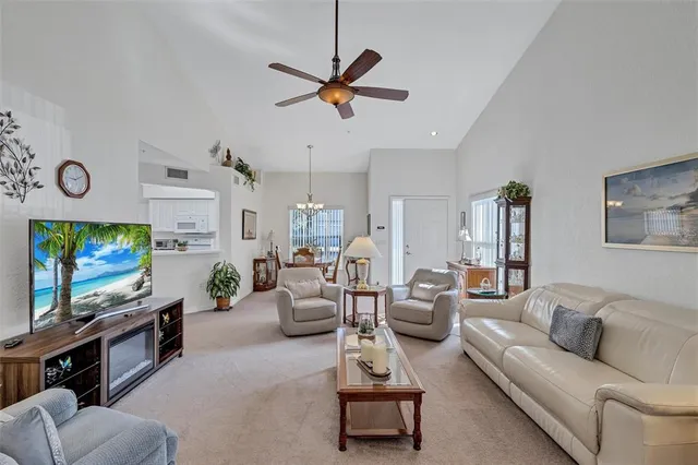 a living room with furniture a flat screen tv and a wall painting