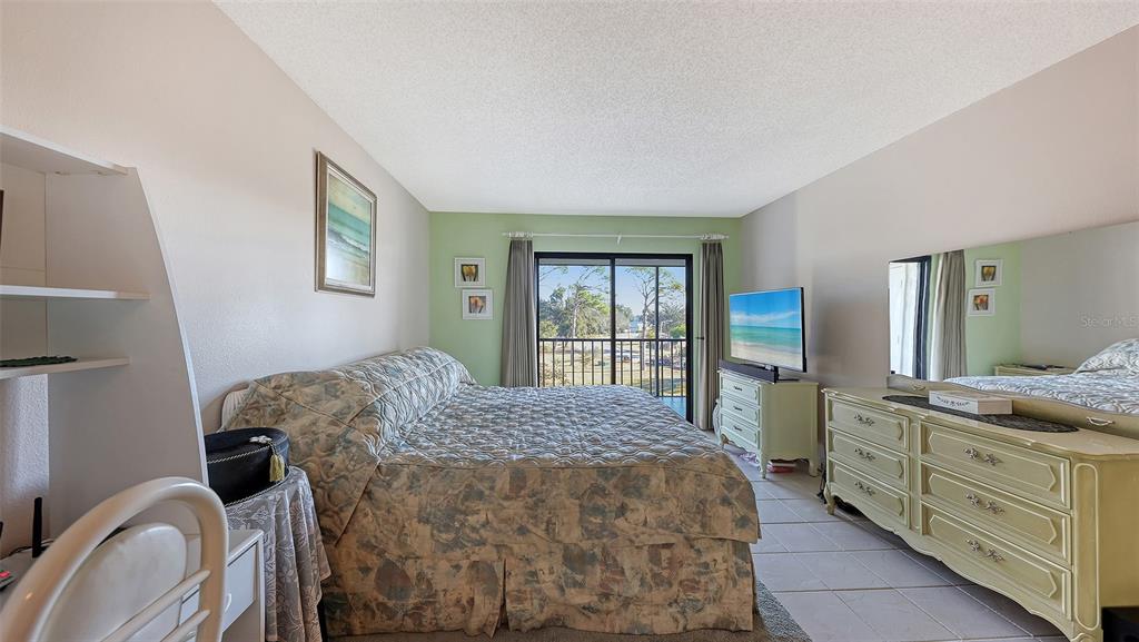 1196 Bird Bay Way, Unit 310 Venice, FL 34285 - Photo 13 of 37 a bed sitting in a bedroom next to a window