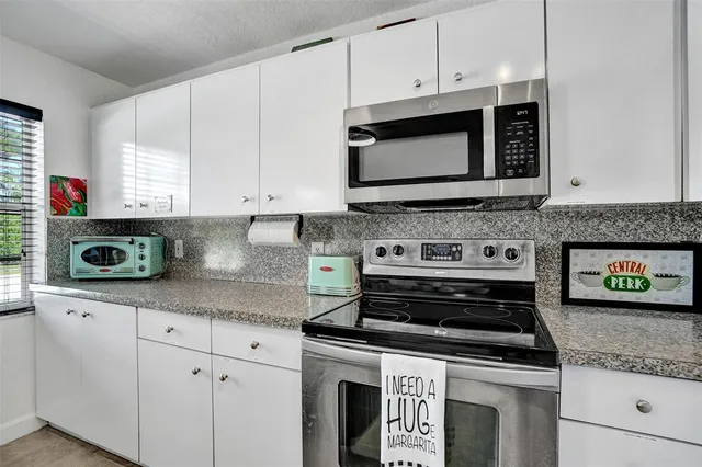 a kitchen with stainless steel appliances granite countertop a stove and a microwave