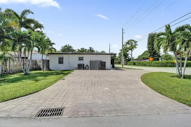 a front view of a house with a yard and potted plants