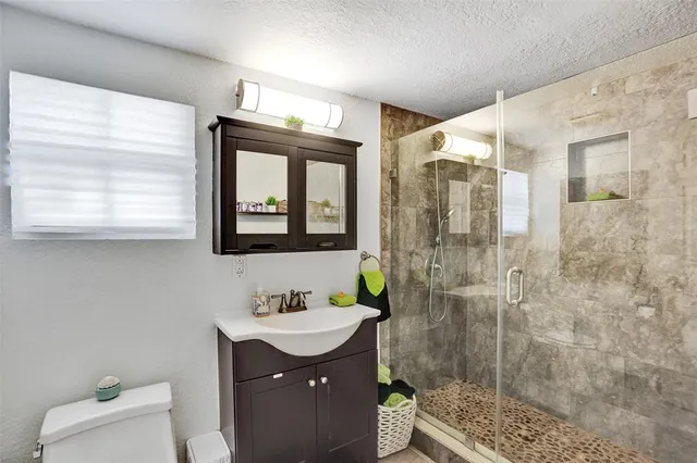 a bathroom with a double vanity sink mirror and shower