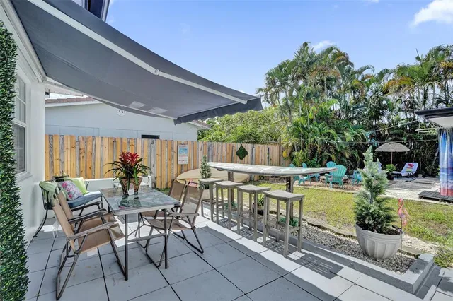 a view of a patio with table and chairs potted plants with wooden floor