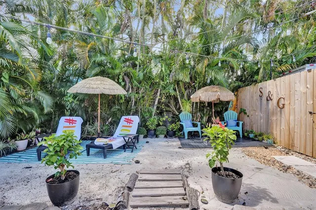 a table and chairs in the patio with potted plants