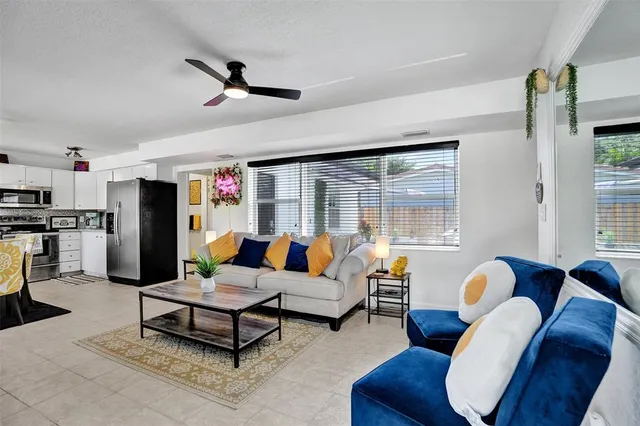 a living room with furniture ceiling fan and a window