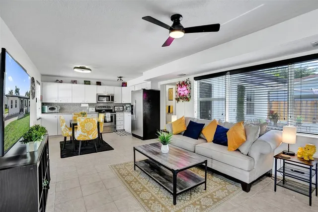 a living room with furniture kitchen view and a window