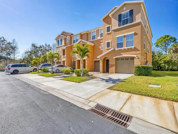 a front view of a house with a yard and car parked