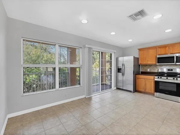 a large kitchen with stainless steel appliances granite countertop a refrigerator and a stove top oven