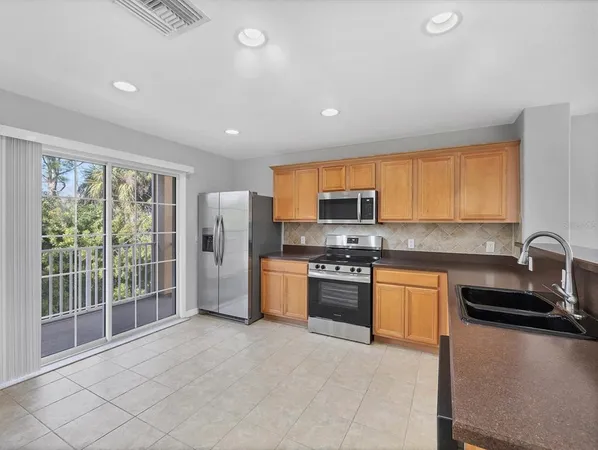 a kitchen with stainless steel appliances granite countertop a refrigerator stove sink and dishwasher