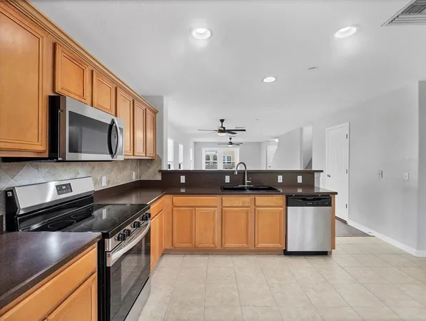 a kitchen with stainless steel appliances a sink a stove top oven a counter space and cabinets