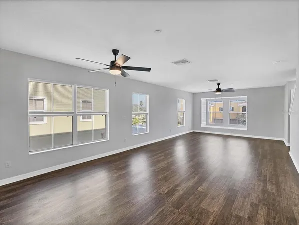 a view of wooden floor and a chandelier fan in a room