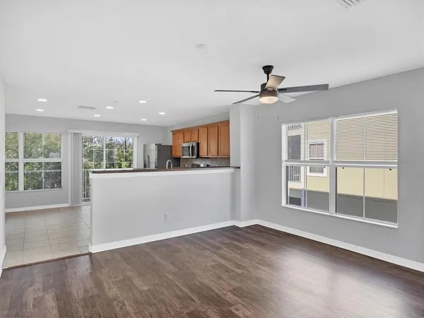 a view of an empty room with a window and wooden floor