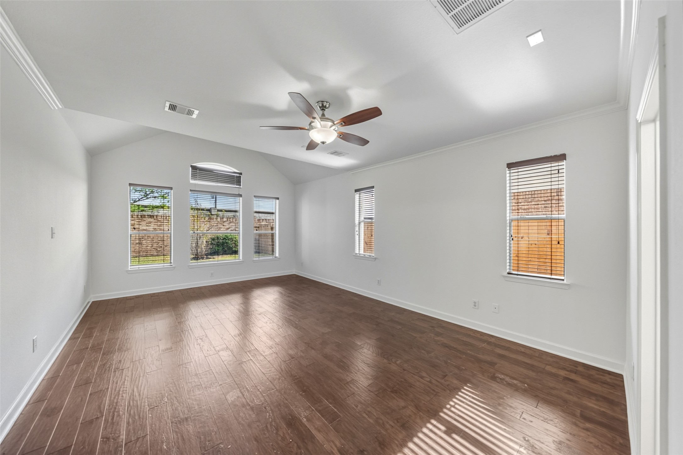 3103 Trail Ridge Drive Pearland, TX 77584 - Photo 16 of 35 an empty room with wooden floor chandelier fan and windows