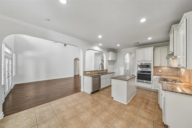 a large kitchen with a large counter top appliances and cabinets