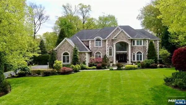 an aerial view of a house with a yard and large trees