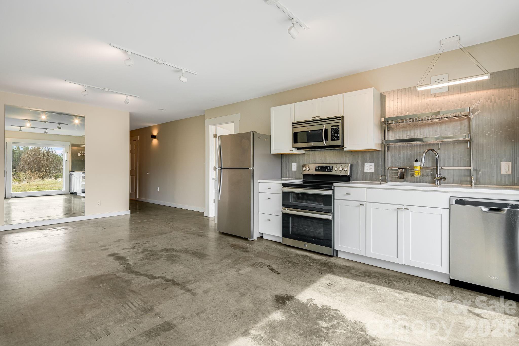 76 Murray De Bruhl Road Alexander, NC 28701 - Photo 36 of 44 a kitchen with granite countertop a refrigerator and a stove top oven