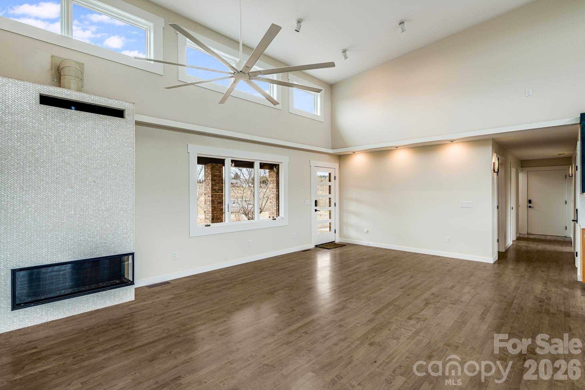 76 Murray De Bruhl Road Alexander, NC 28701 - Photo 8 of 44 an empty room with wooden floor fan and windows