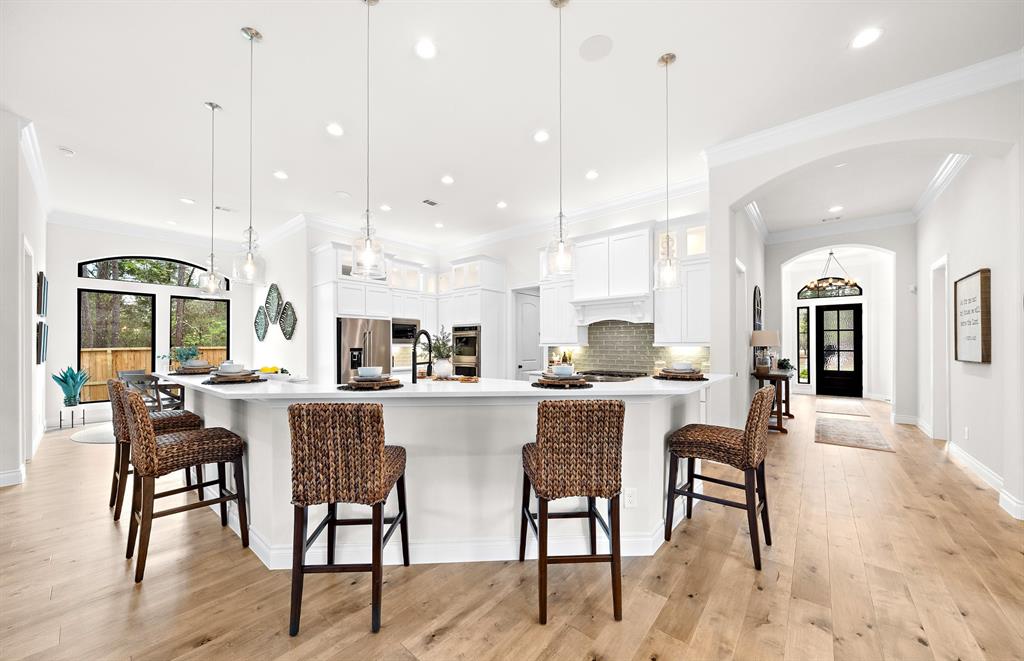 a dining hall with stainless steel appliances kitchen island a table and chairs