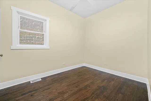 an empty room with wooden floor and a window