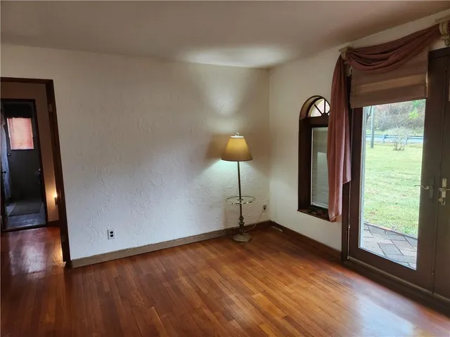 a view of a livingroom with wooden floor and a window